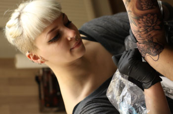Tattoo Artist Zoe Lodge beim Tätowieren